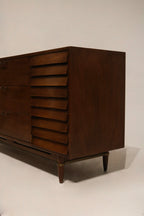 Hardware close-up showing original drawer pulls and fasteners with vintage patina on walnut facade