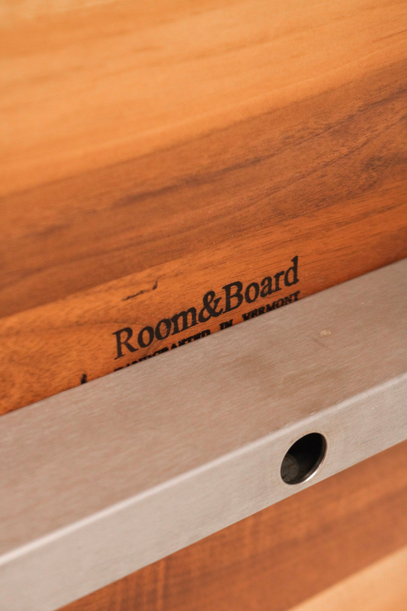 Close-up of solid wood tabletop with visible natural grain and minor surface marks