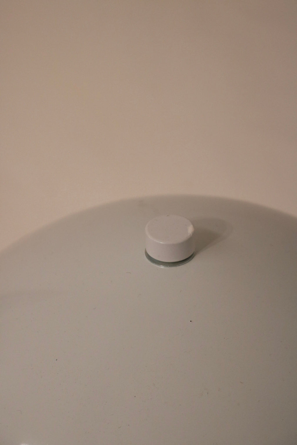 Side angle detail showcasing curvature of the white metal dome and modern shape