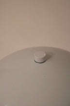 Side angle detail showcasing curvature of the white metal dome and modern shape