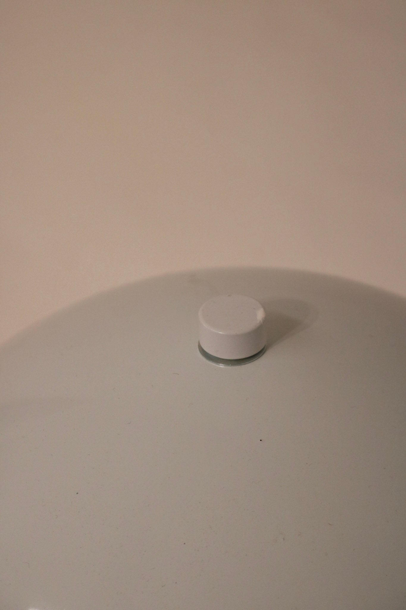 Side angle detail showcasing curvature of the white metal dome and modern shape