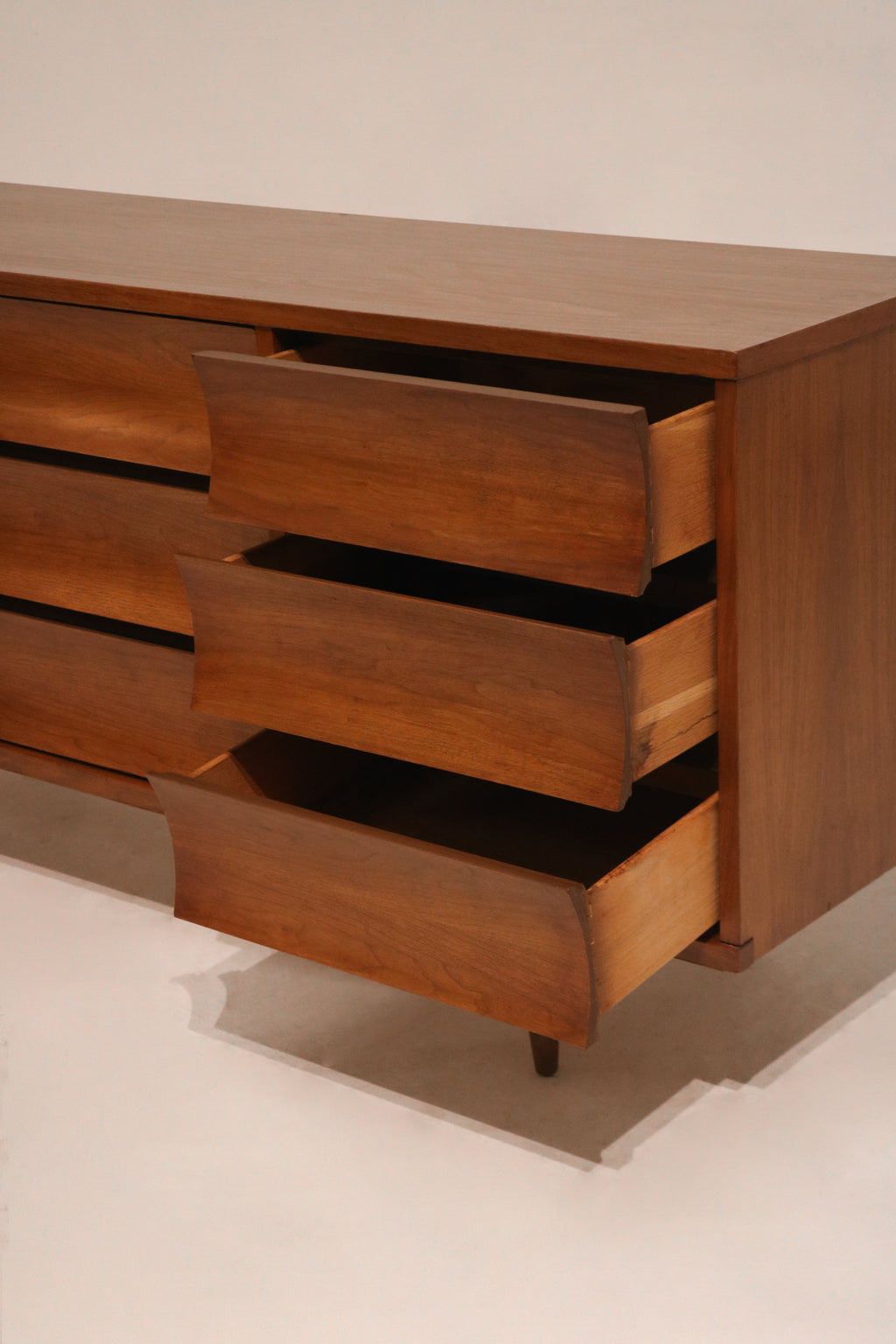 Side profile shot showcasing the depth and walnut veneer finish of the dresser