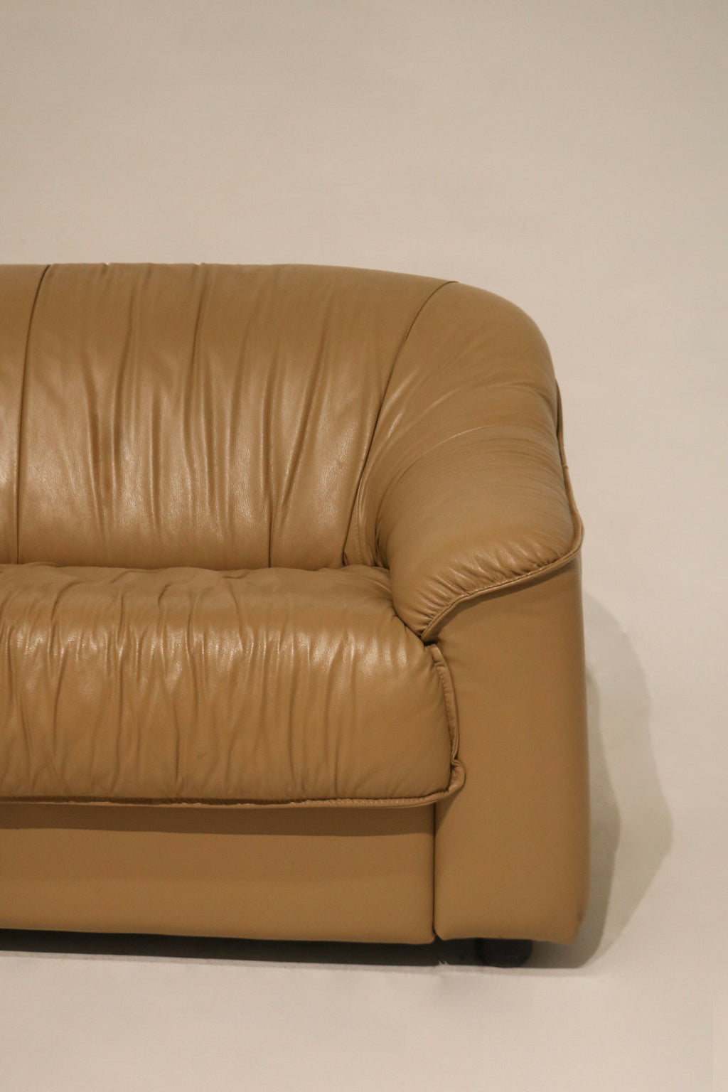 Side profile of the vintage leather sofa with visible cushioning and armrest
