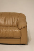 Side profile of the vintage leather sofa with visible cushioning and armrest