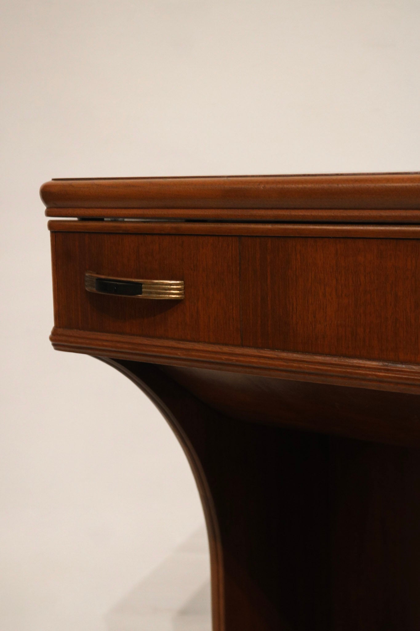 Detail: interior storage cavity view of walnut wood desk with lighting revealing brackets, supports and storage space