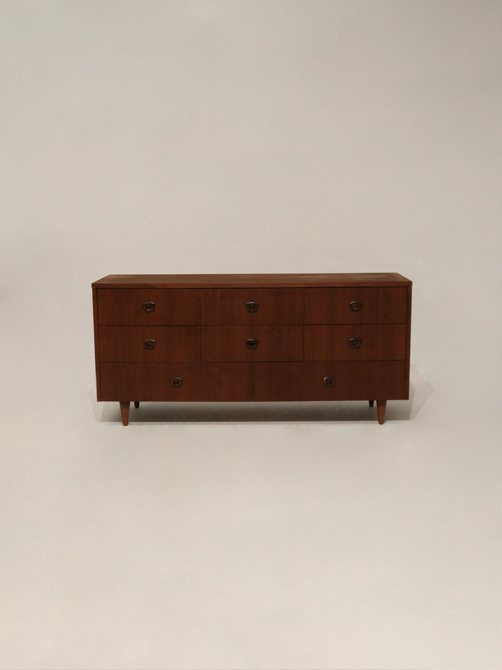 Front angled view of Mid Century Modern walnut wood dresser with 8 drawers by Bassett Furniture