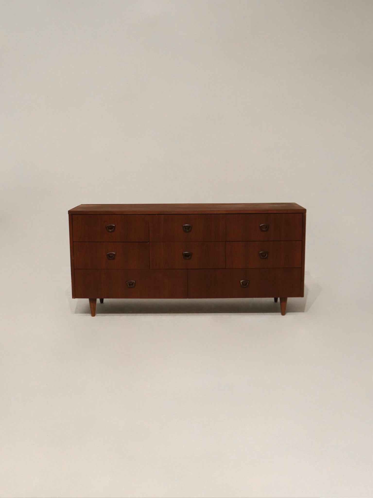 Front angled view of Mid Century Modern walnut wood dresser with 8 drawers by Bassett Furniture