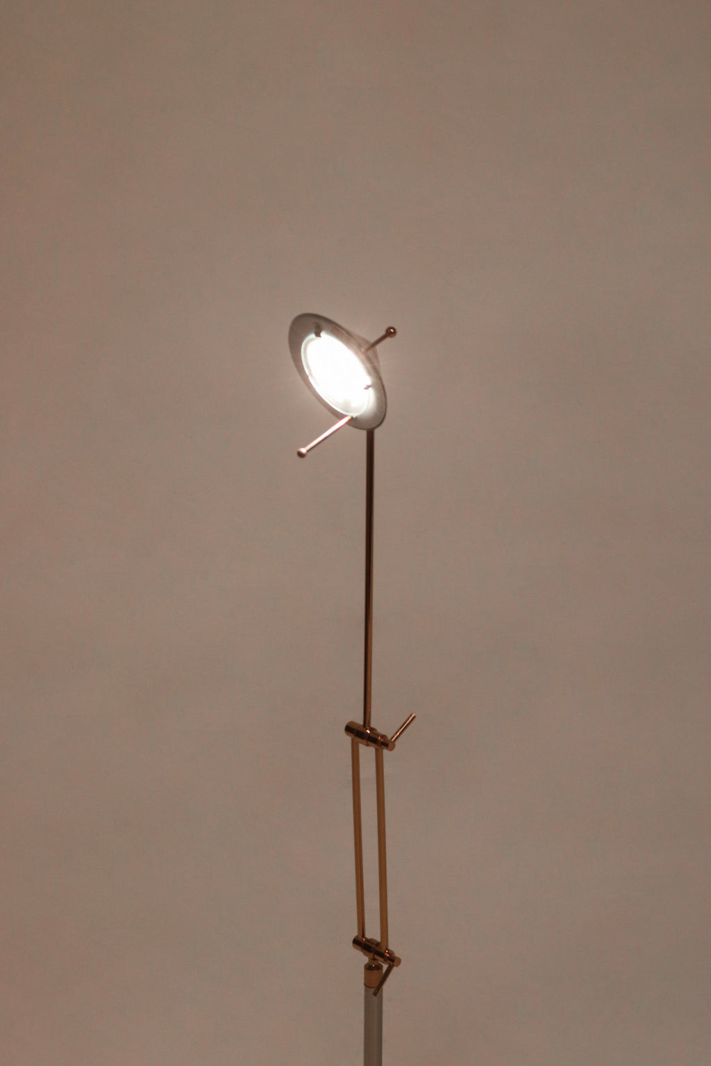 Close-up of chrome lamp base with polished steel texture and minimalist circular design