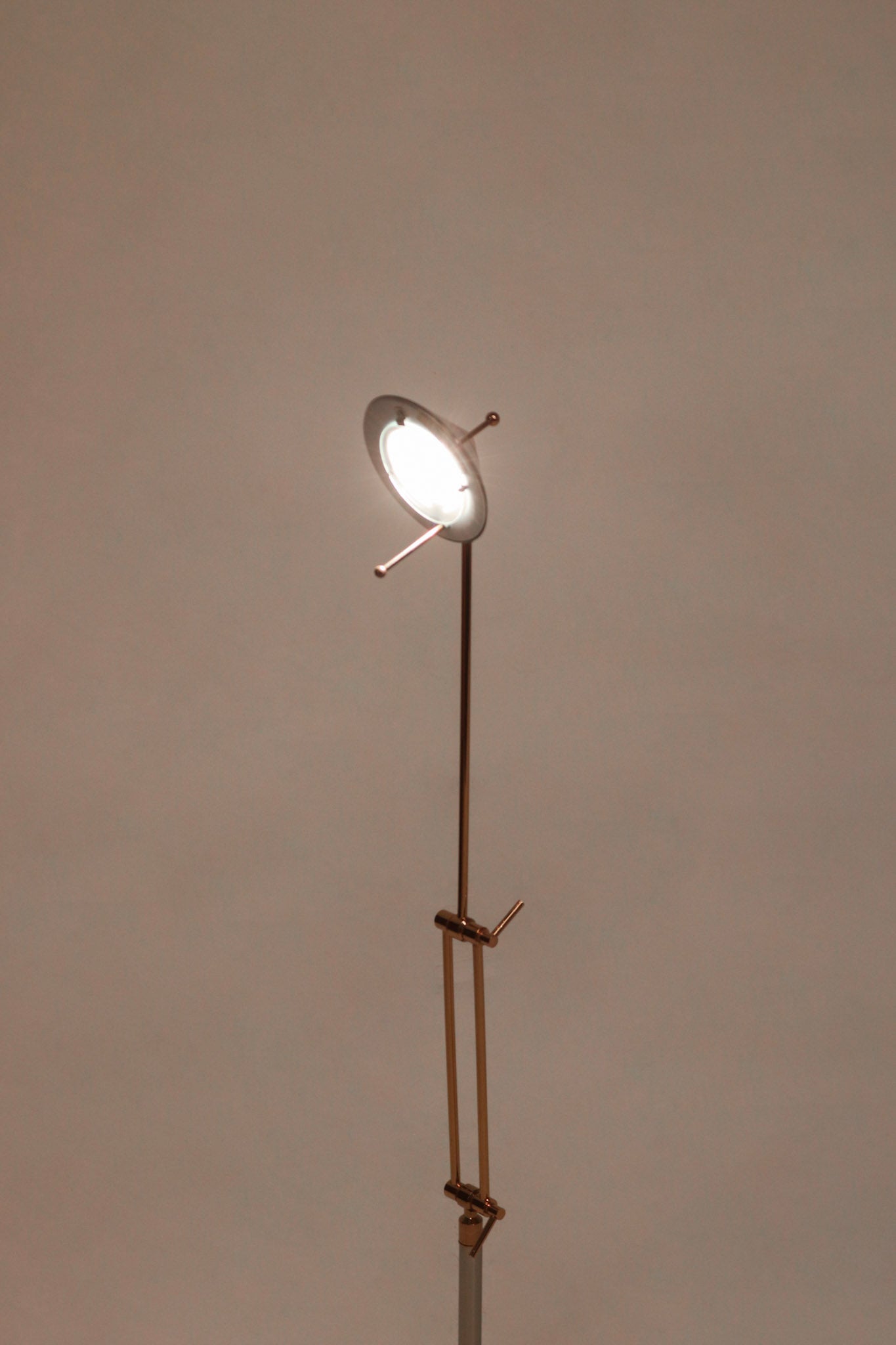 Close-up of chrome lamp base with polished steel texture and minimalist circular design