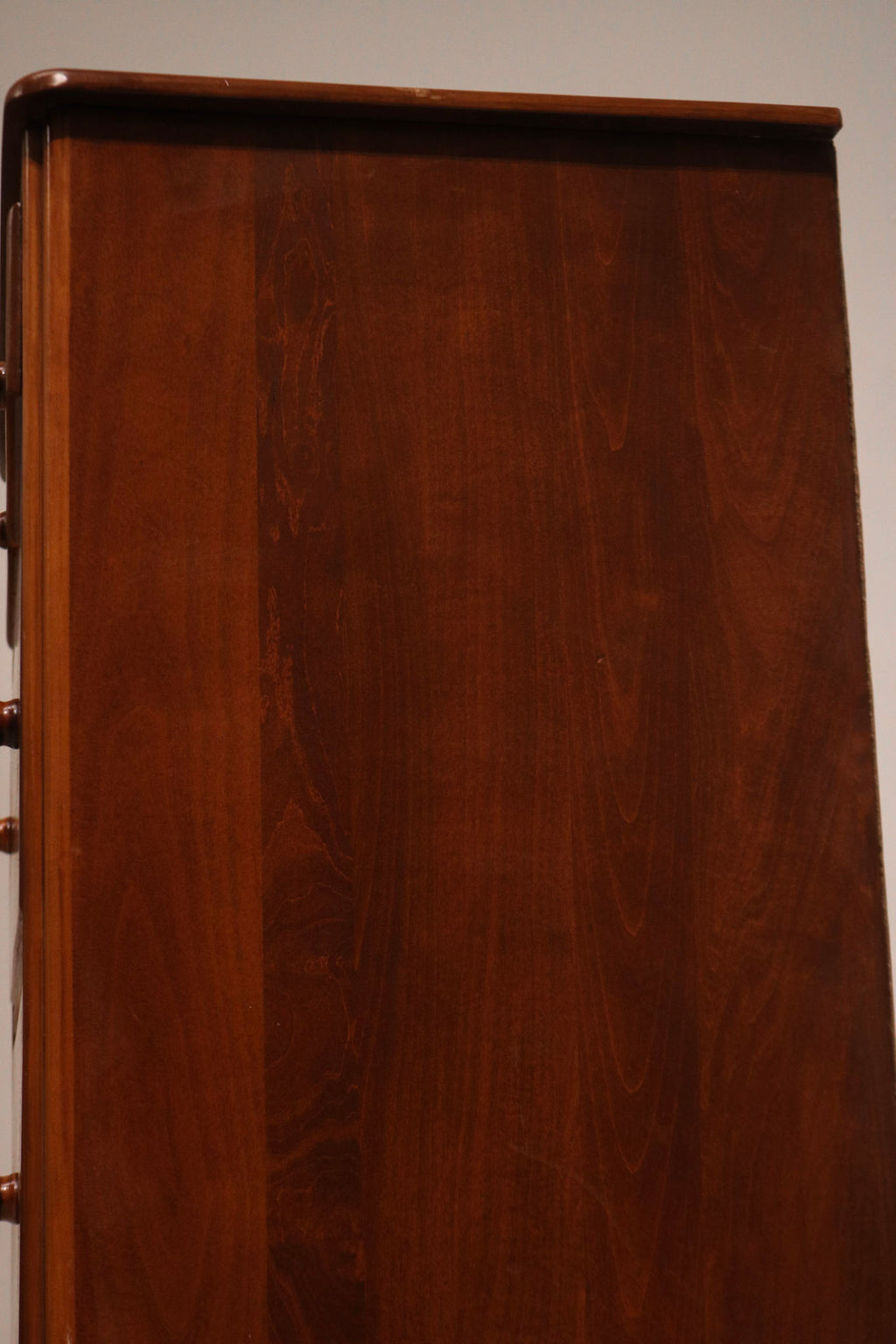 Macro close-up of maple wood grain and lacquered finish on dresser exterior