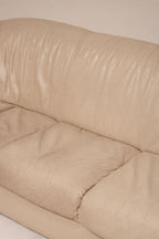 Detailed image of tiny hole close-up in beige leather upholstery of Natuzzi sofa