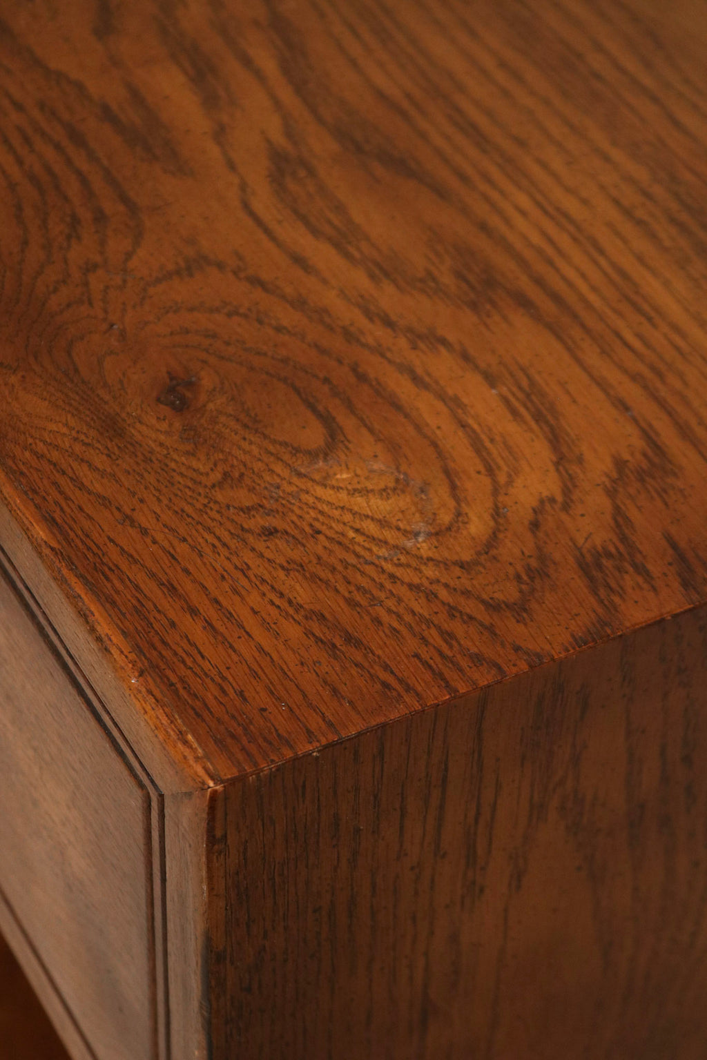 Detail of drawer front and brass knob on Vintage Mcm Oak Nightstand, highlighting solid wood construction