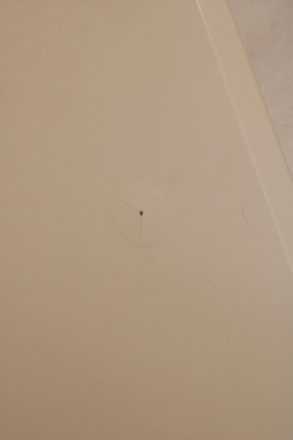 Top-down image of nightstand surface finish displaying white lacquer color and sheen