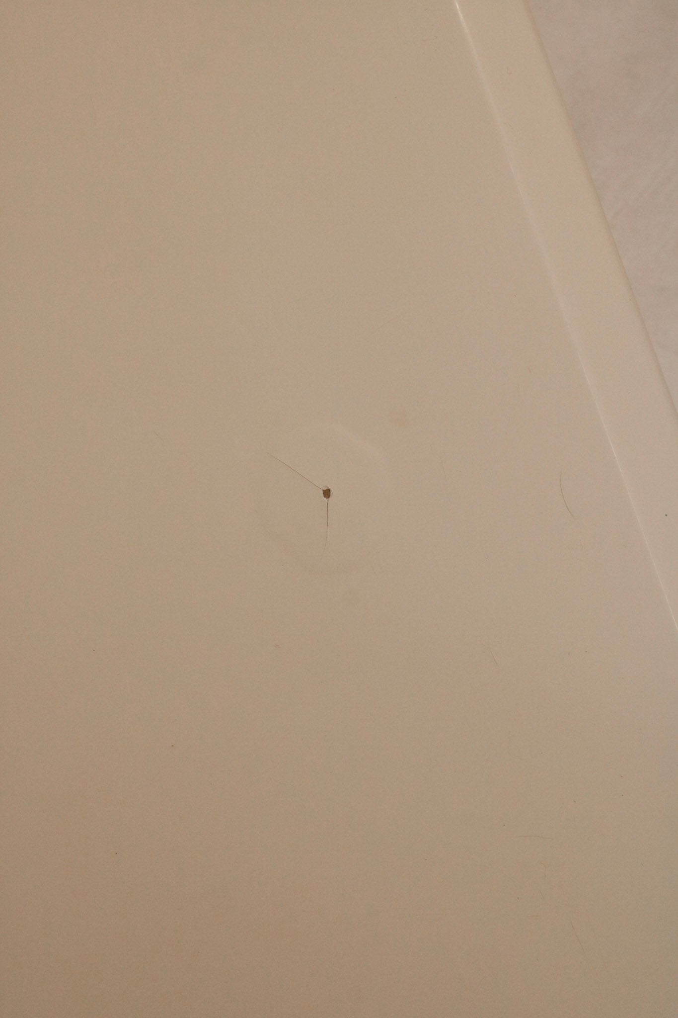 Top-down image of nightstand surface finish displaying white lacquer color and sheen