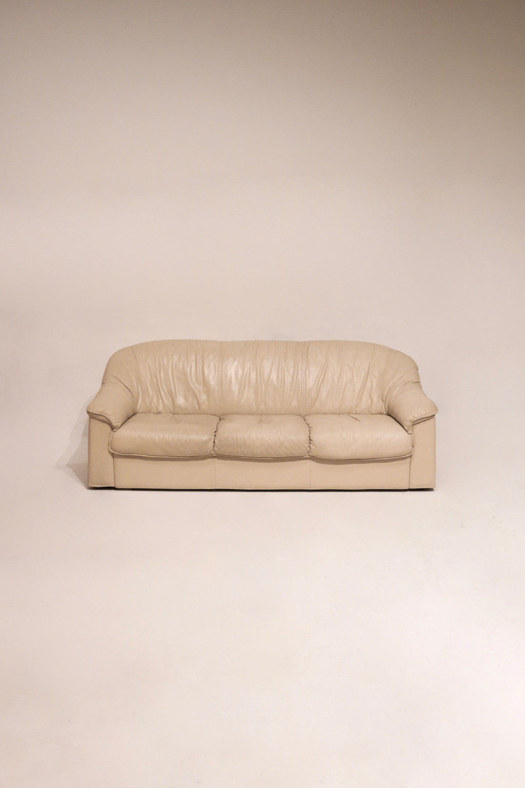 Full view of vintage Salotti Natuzzi beige Italian leather sofa with visible texture and clean lines