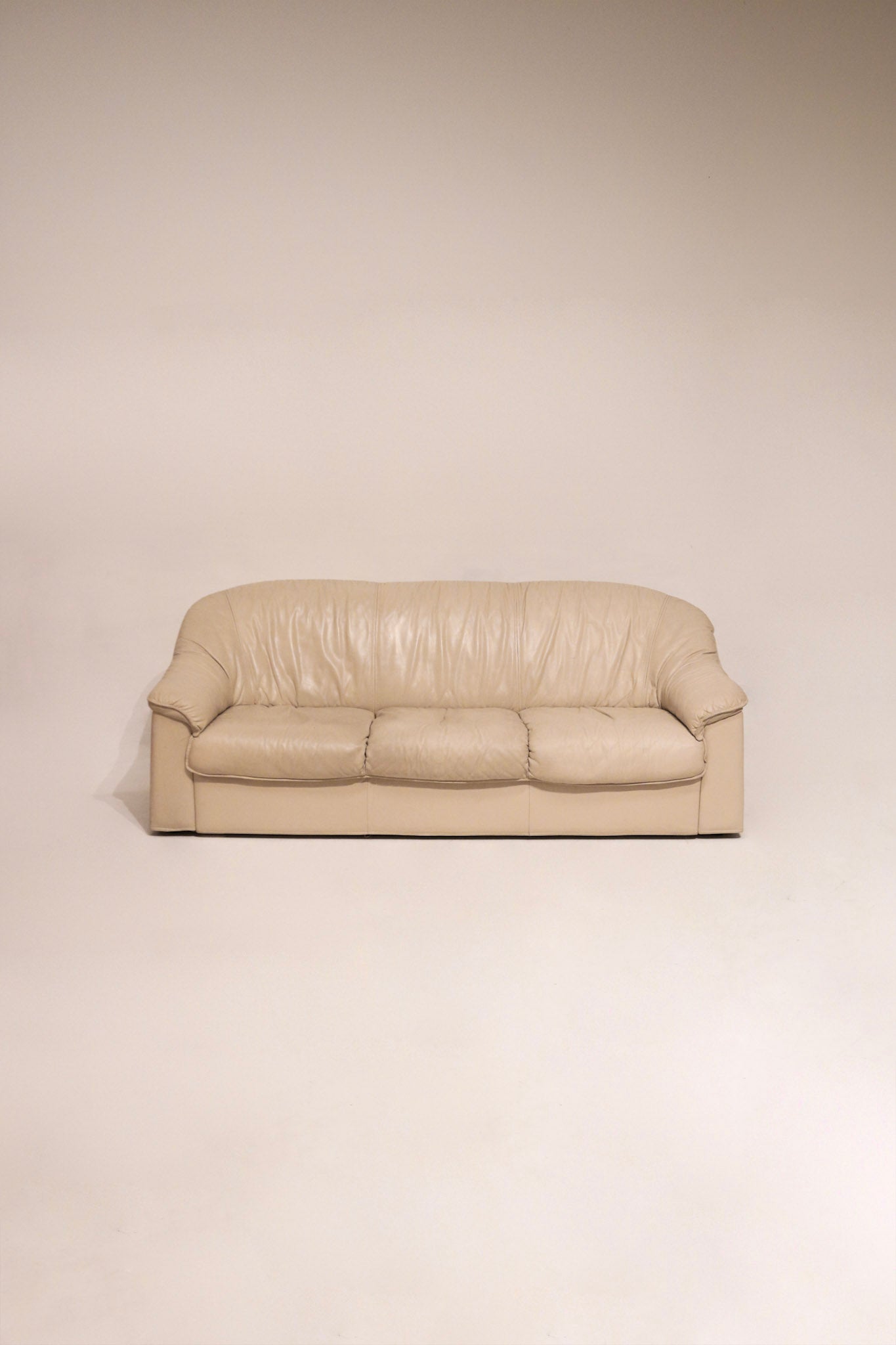 Full view of vintage Salotti Natuzzi beige Italian leather sofa with visible texture and clean lines