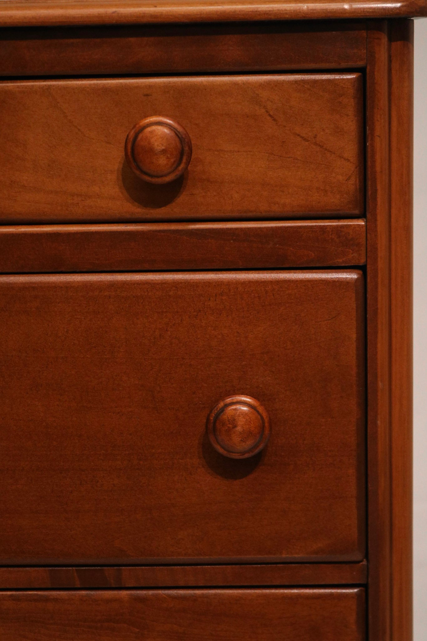 Angle shot of highboy dresser corner showing wood grain and finish quality
