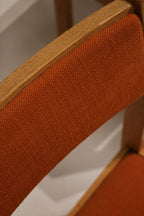 Group arrangement of all four Jasper chairs around a dining table showcasing cohesive MCM design, oak frames and orange tweed seats.