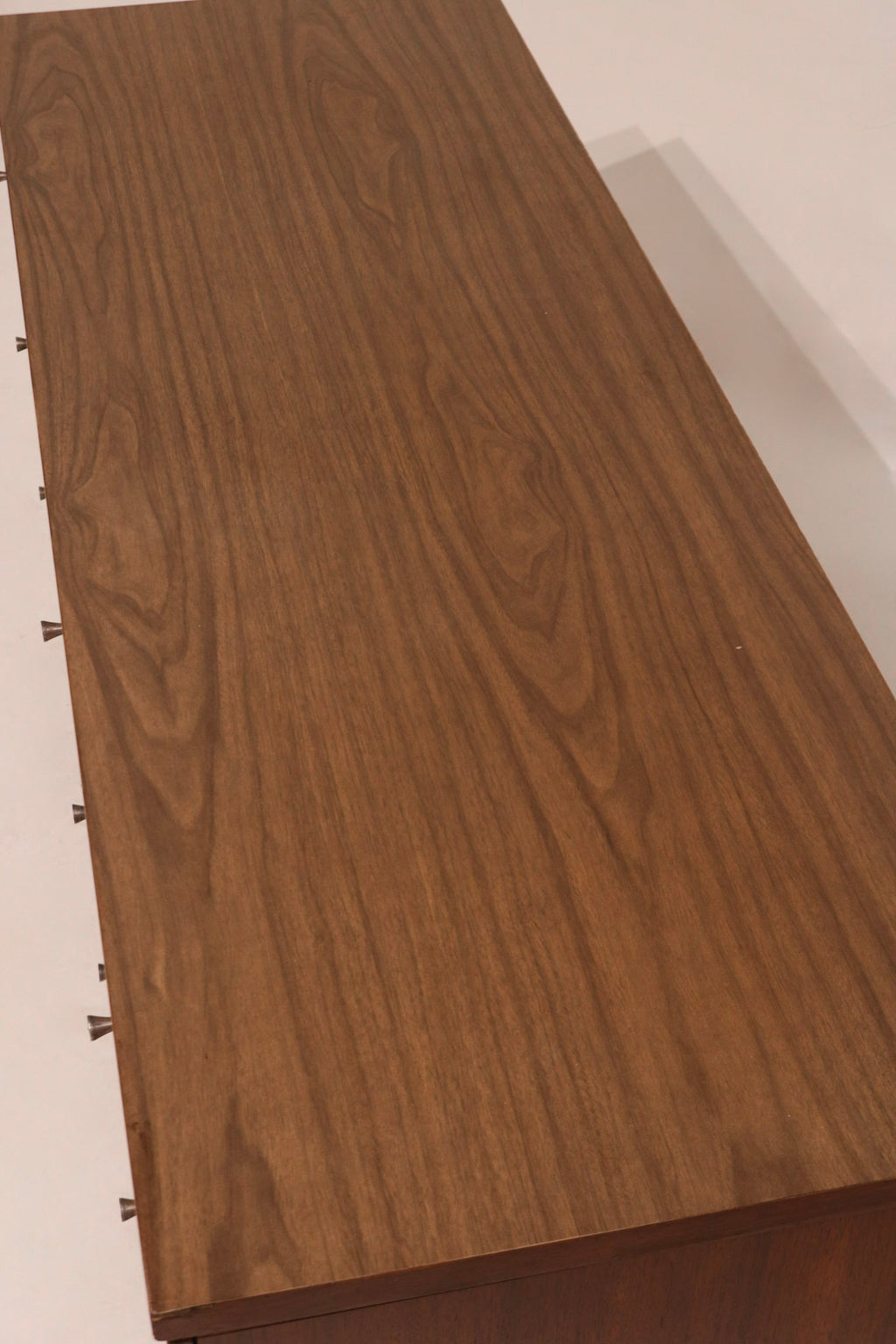 Zoomed-in shot of drawer hardware demonstrating patina and vintage detailing on brass