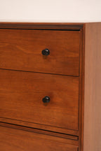 Close-up of walnut wood grain showing natural texture and smooth finish on dresser surface