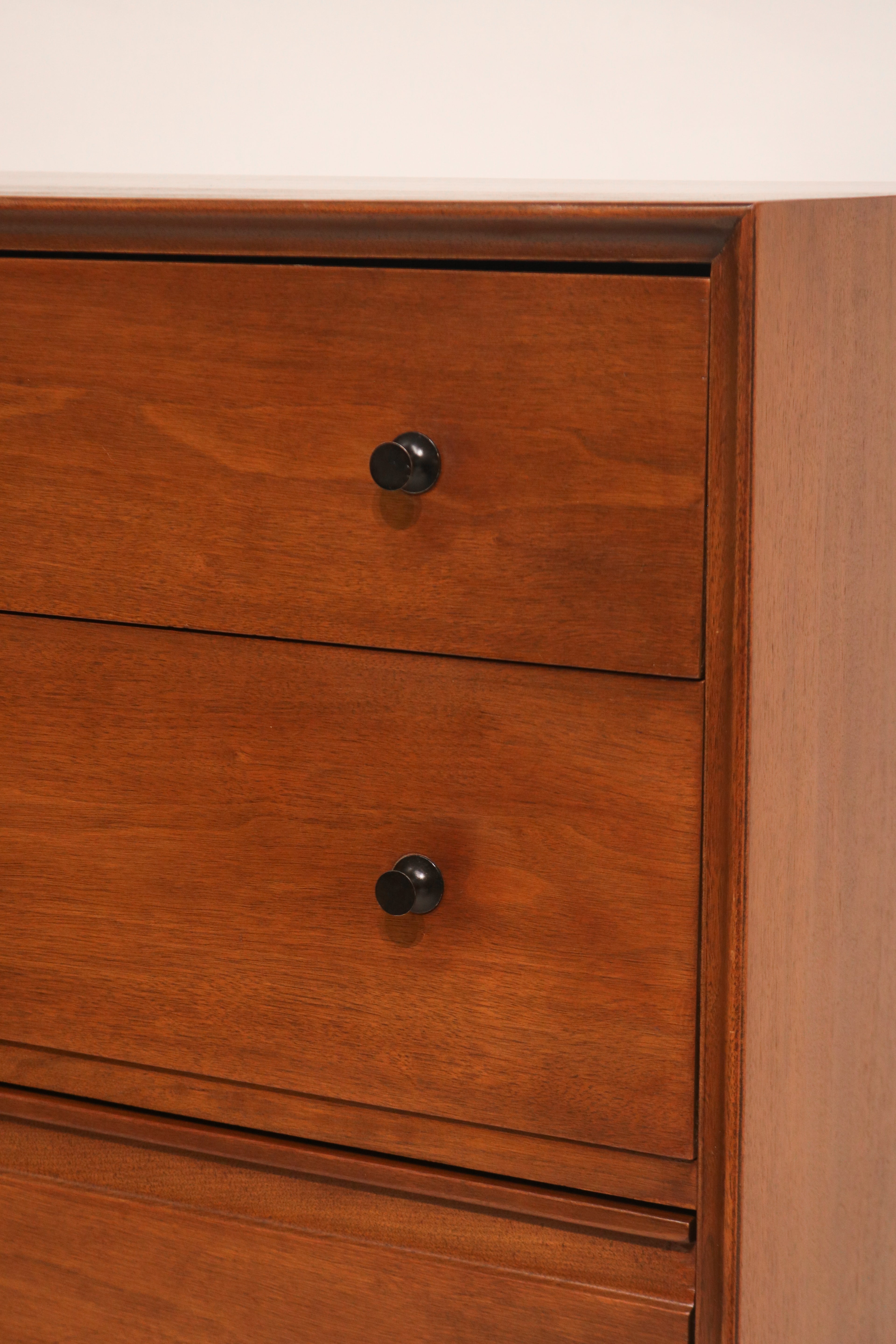 Close-up of walnut wood grain showing natural texture and smooth finish on dresser surface
