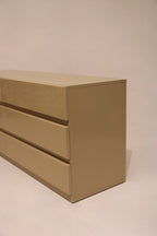 Close-up of dresser legs illustrating mid-century design and wood finish continuity