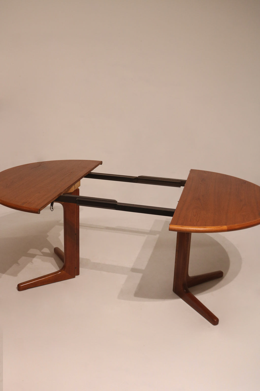Side angle showing proportional legs and rounded corners of teak dining table