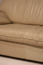 Detail shot of sofa armrest in real Italian leather, showcasing flawless beige upholstery