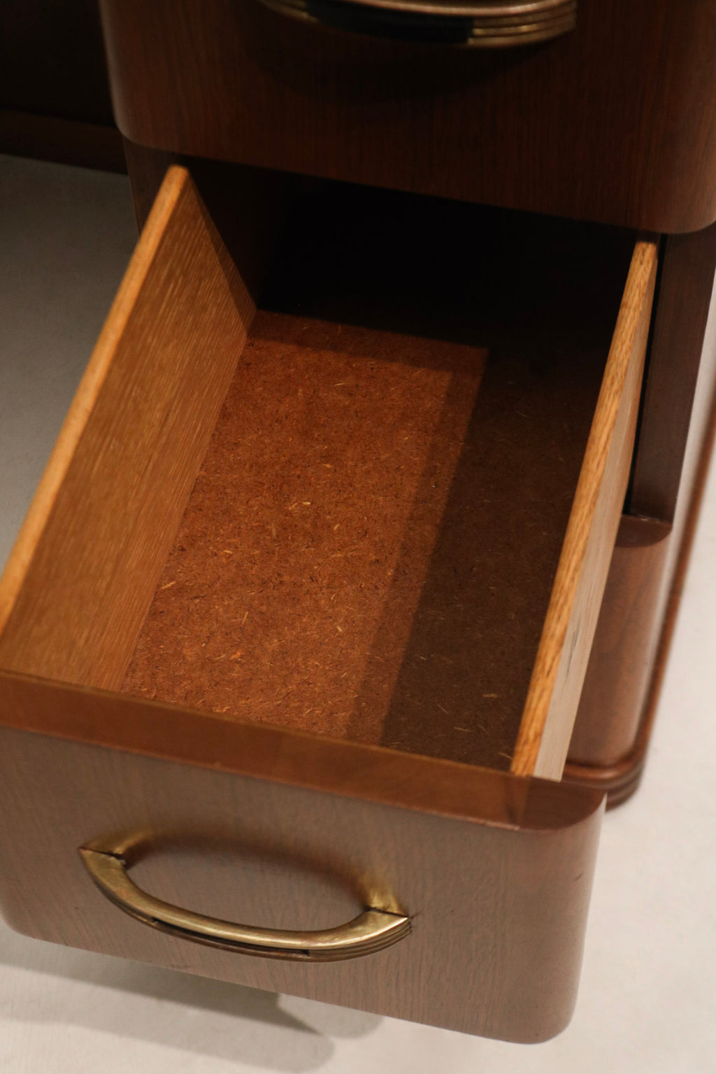 Corner close-up of walnut wood desk showing minor scuff and repaired area with matching walnut finish and patina