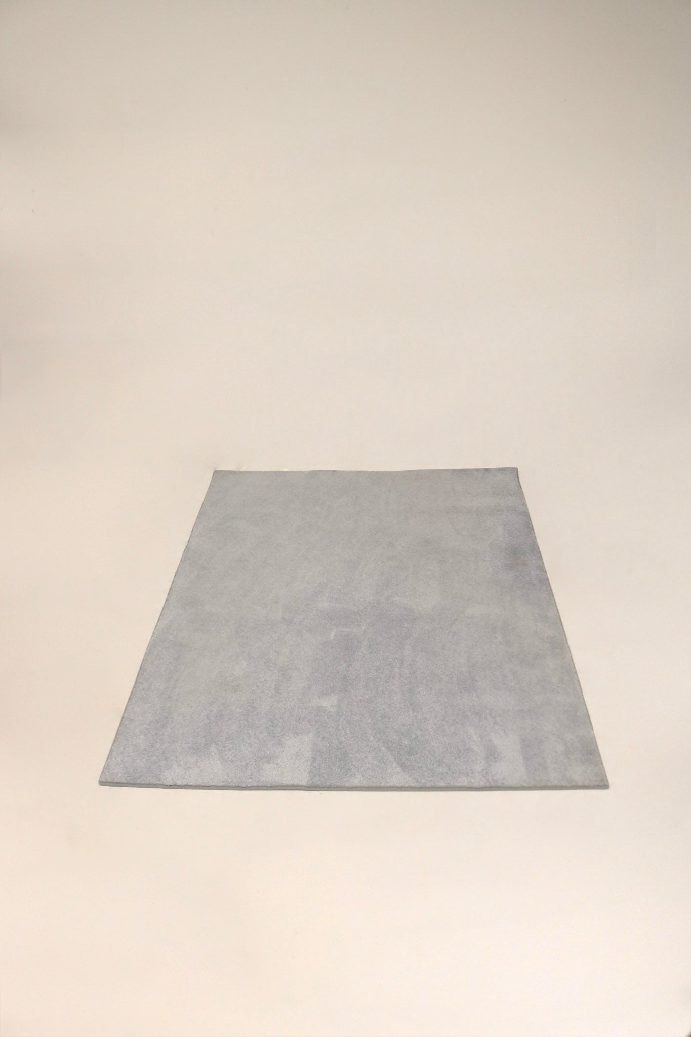 Full view of modern light blue/gray fabric area rug carpet, 83x60 in, cleaned, low-pile texture and soft muted tones.