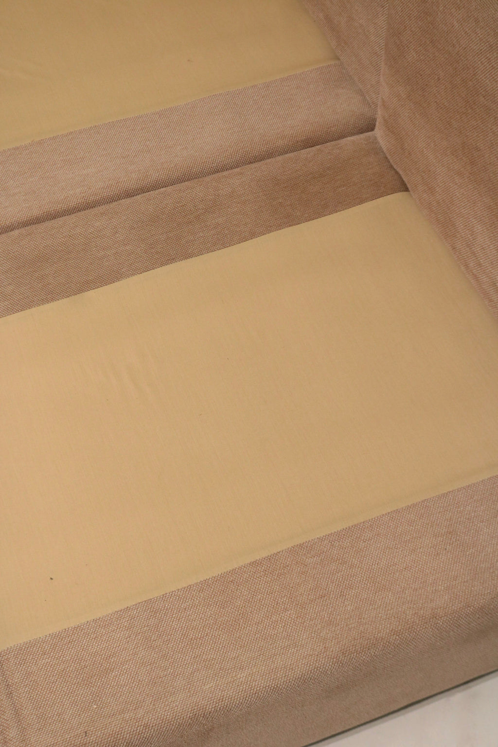 Close-up of fabric pattern and color variation on Mcm sectional sofa showing brown-dominant hue with subtle pink undertones in weave