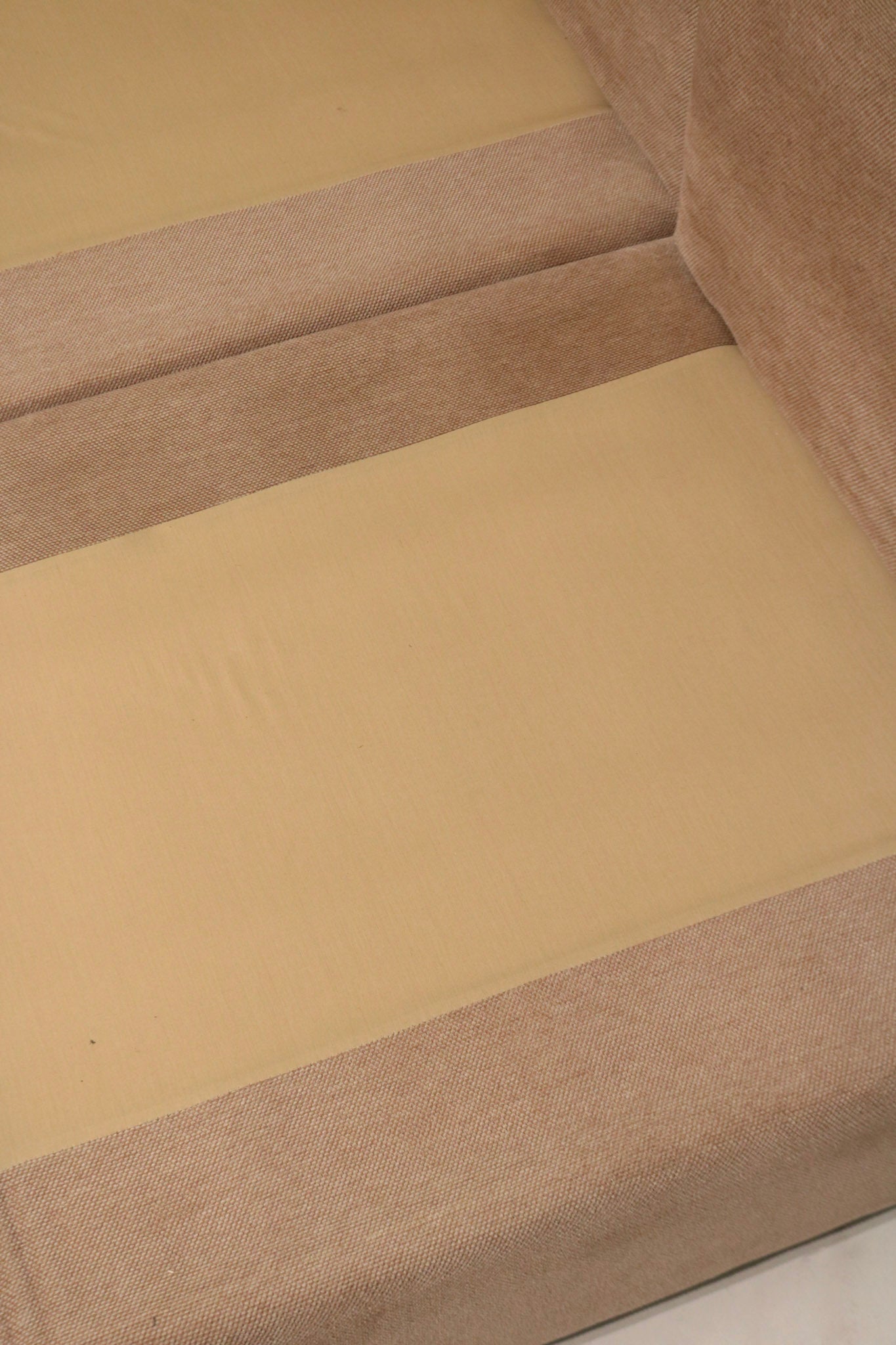 Close-up of fabric pattern and color variation on Mcm sectional sofa showing brown-dominant hue with subtle pink undertones in weave