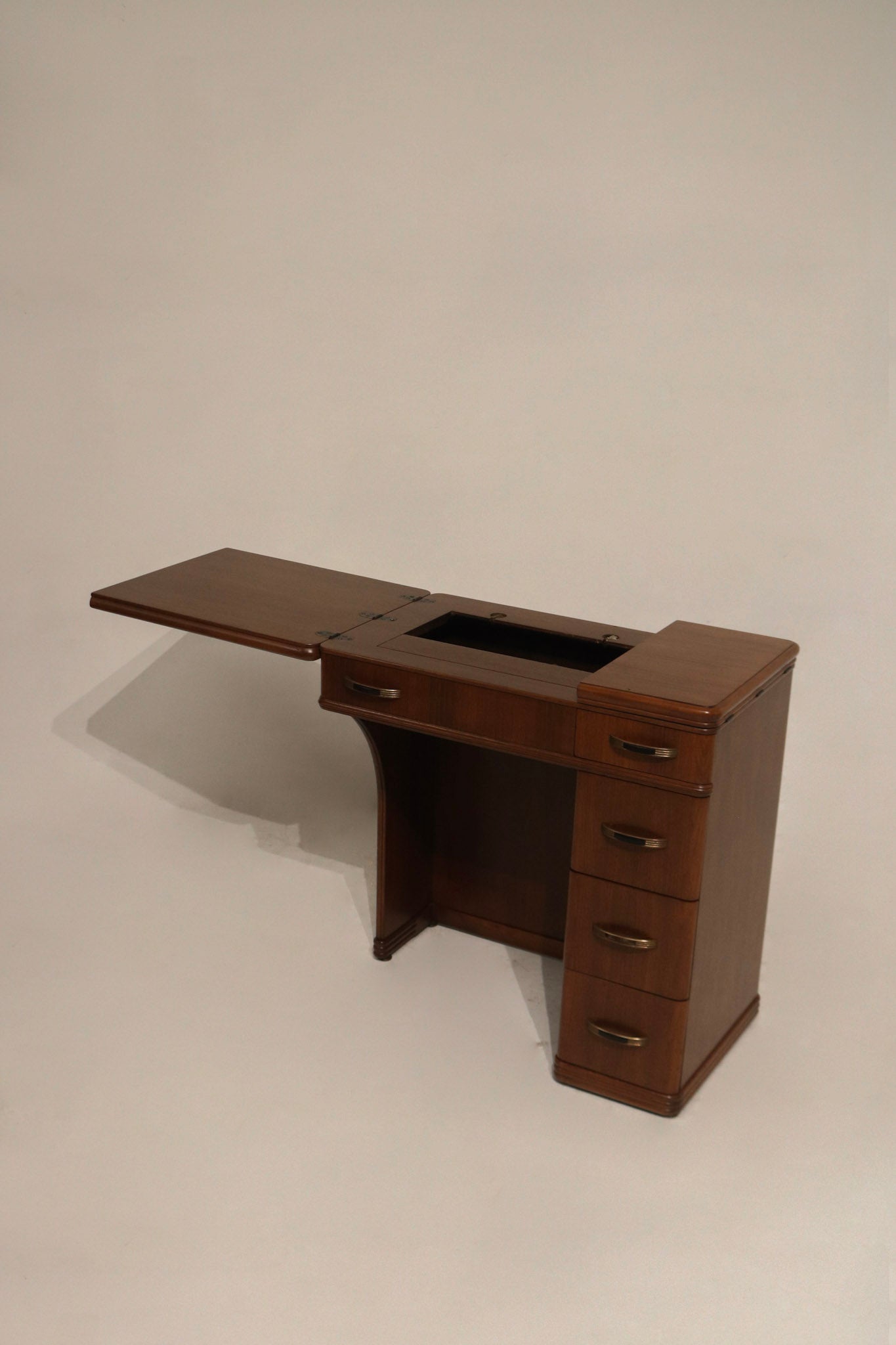 Detail: right leaf extended view of walnut wood side table with smaller leaf open, showing seam and hardware alignment