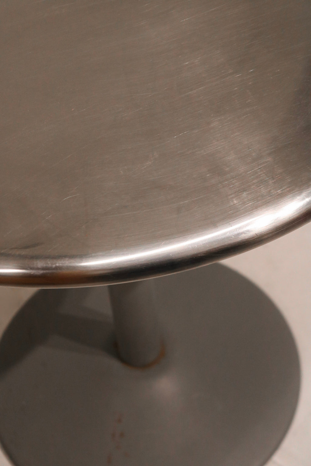 Close-up of round tabletop edge showing durable steel surface and clean welds
