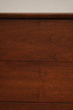 Detail of one drawer's handle on Mcm walnut dresser showing solid wood and vintage pull