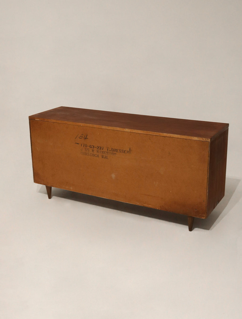 Close-up of solid walnut wood grain on front drawer panels with natural finish