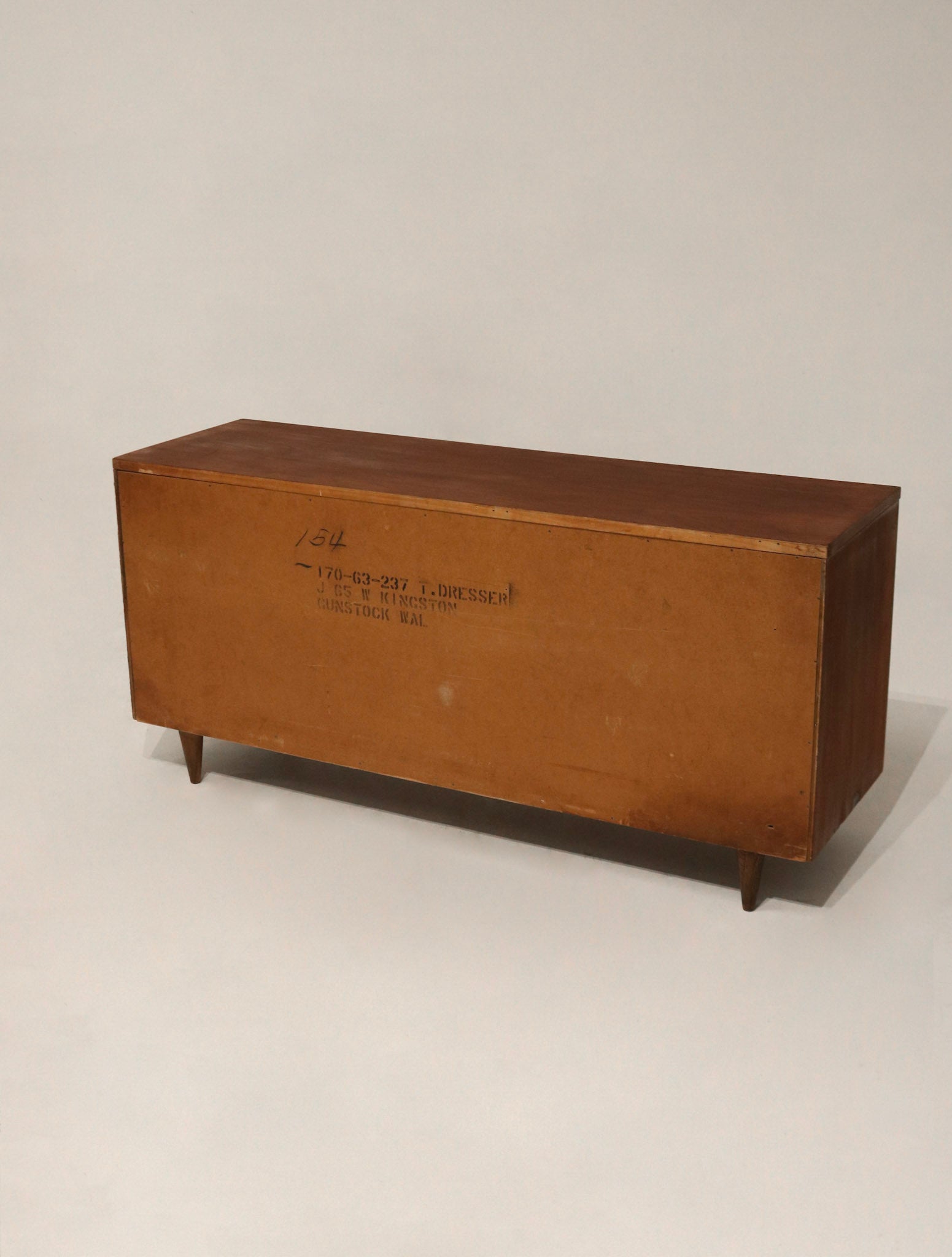 Close-up of solid walnut wood grain on front drawer panels with natural finish