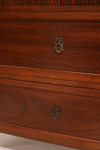 Close-up of the drawer handle in brushed metal, contrasting beautifully with the warm mahogany wood