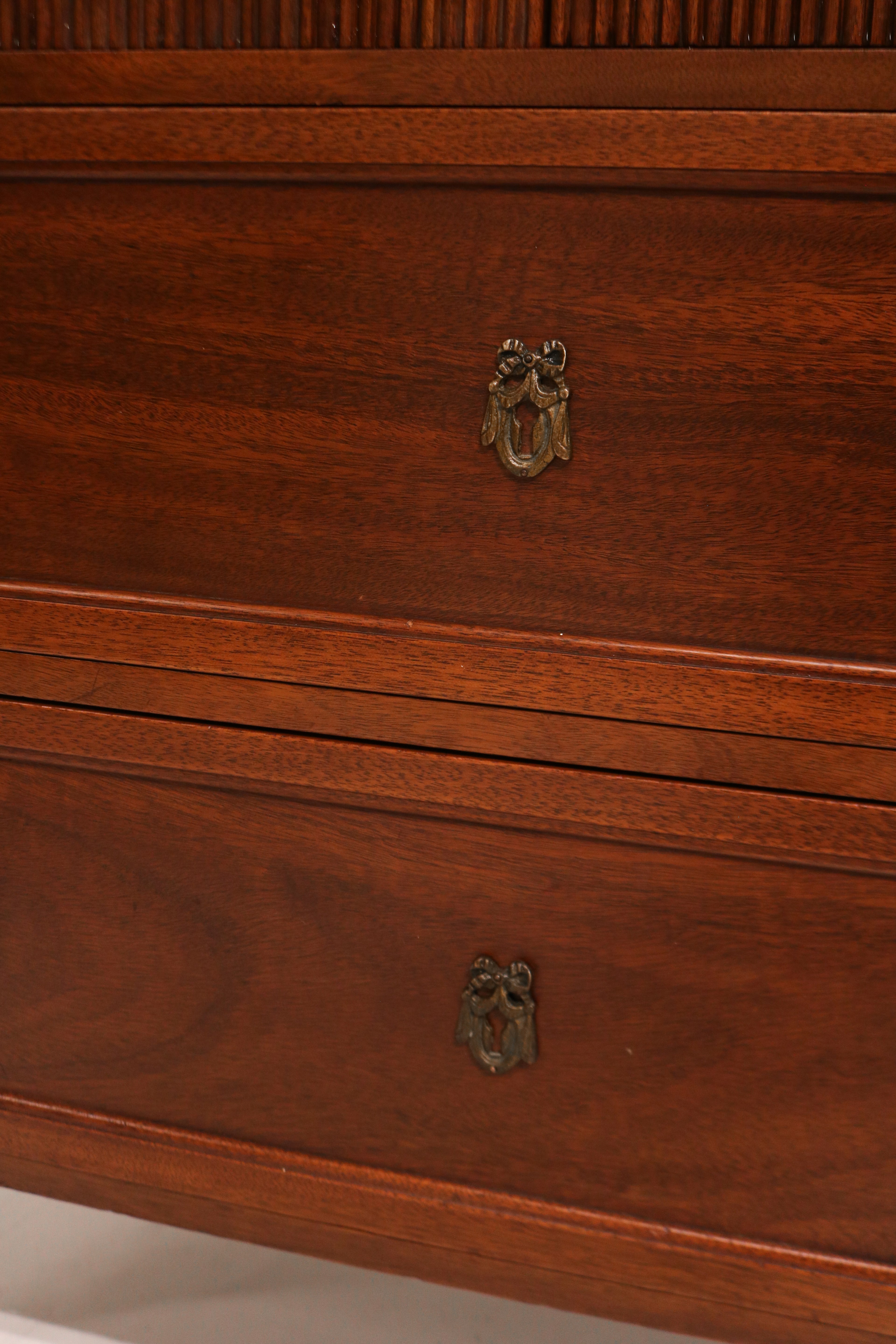 Close-up of the drawer handle in brushed metal, contrasting beautifully with the warm mahogany wood