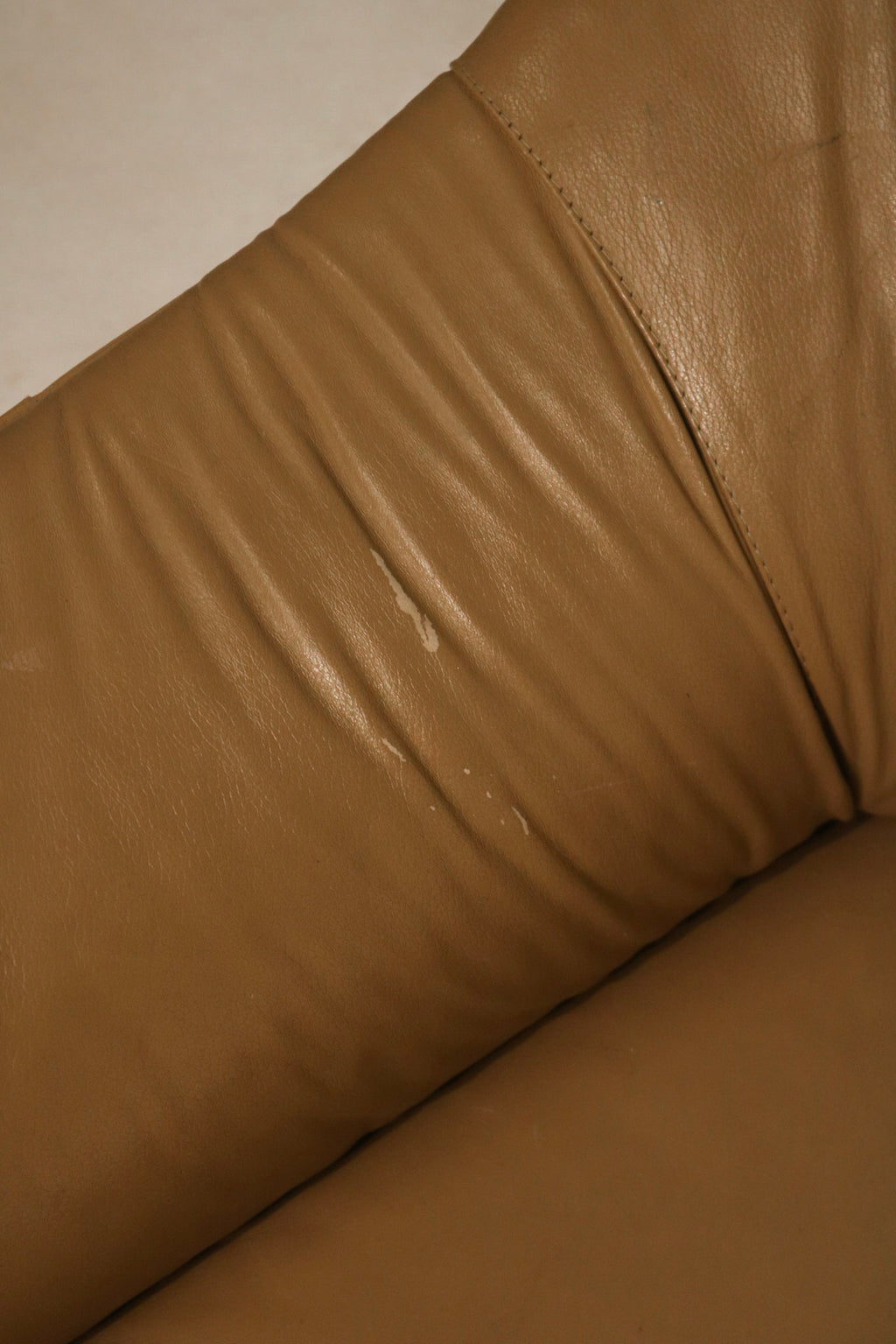 Close-up showing high-quality upholstery and wear pattern on vintage seat