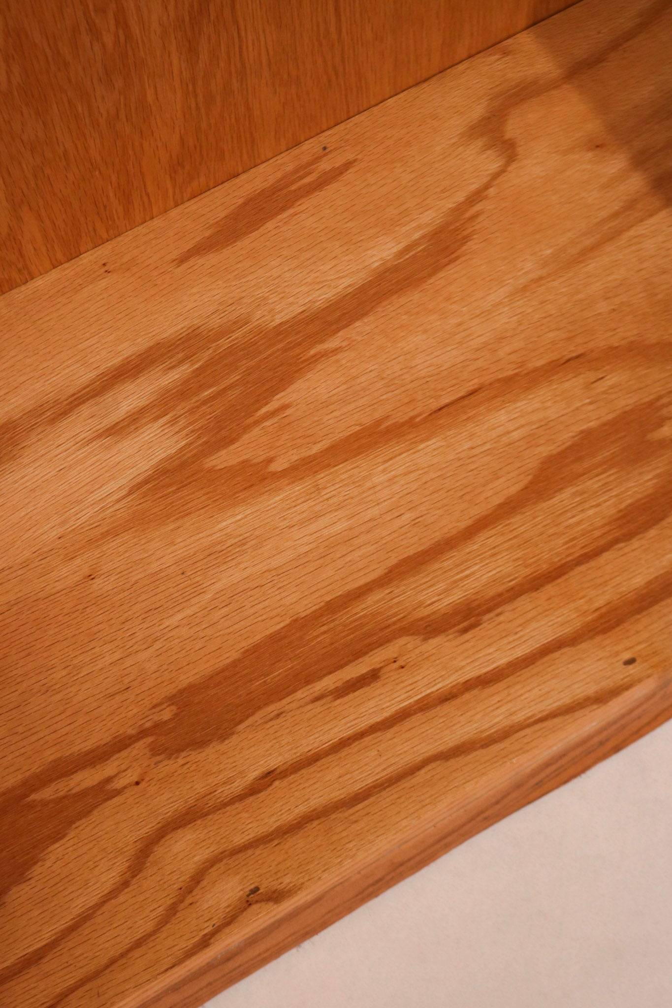 Adjustable shelving system inside the tall oak wood bookcase with mid-century modern vibe