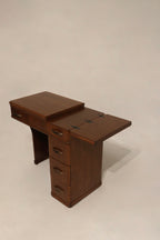 Detail: close-up of drawer hardware on walnut wood desk, metal handles with one missing black plastic part and working drawers