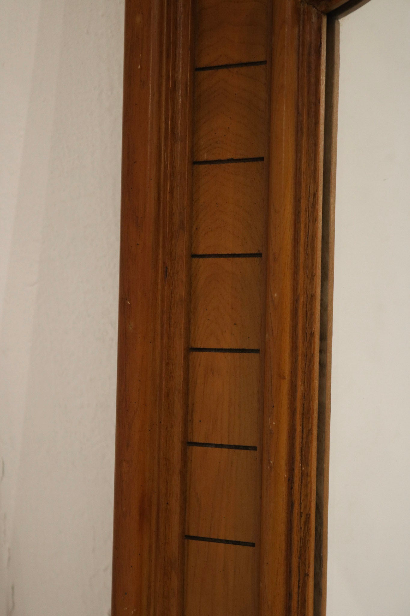 Detail of oak wood frame showing maker's marks, screw heads, patina and finish imperfections that confirm vintage origin.