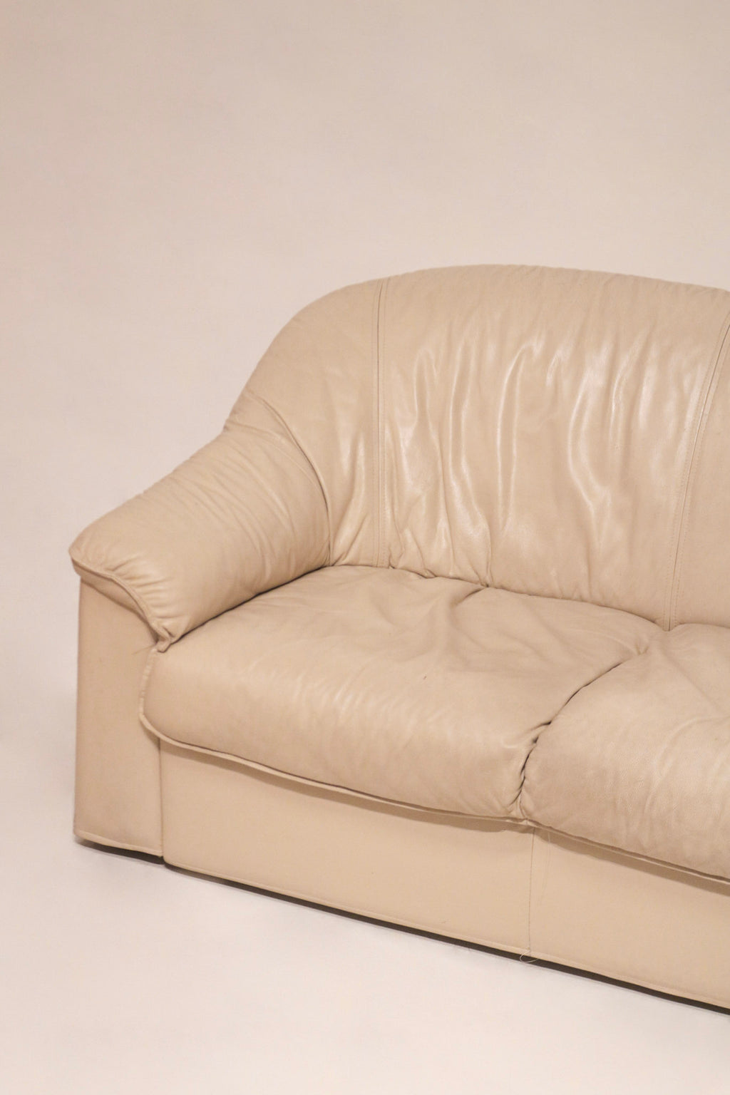 Zoomed-in view of leather grain and stitching on Salotti Natuzzi beige sofa armrest