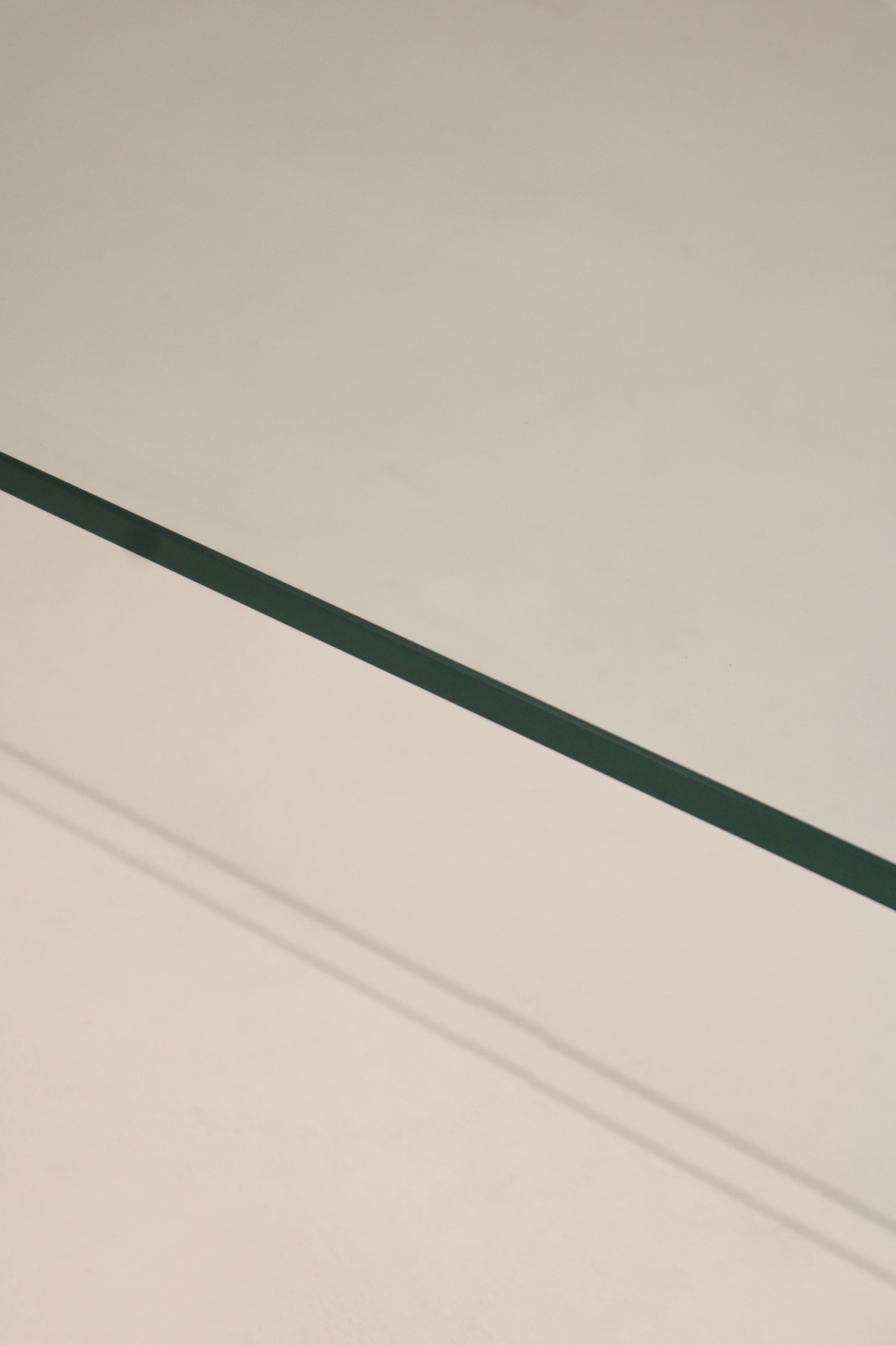 Detail of the curved edge and seamless glass bend on this Contemporary Modern waterfall coffee table