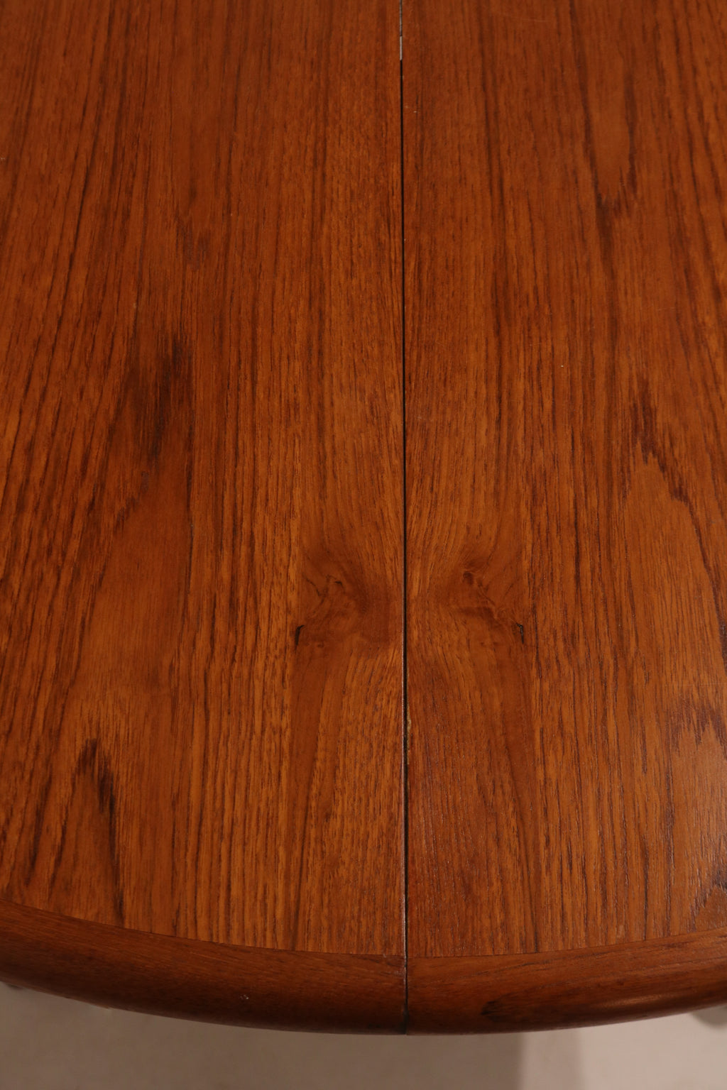 Close-up of extended table with leaf inserted, transforming into large oval shape