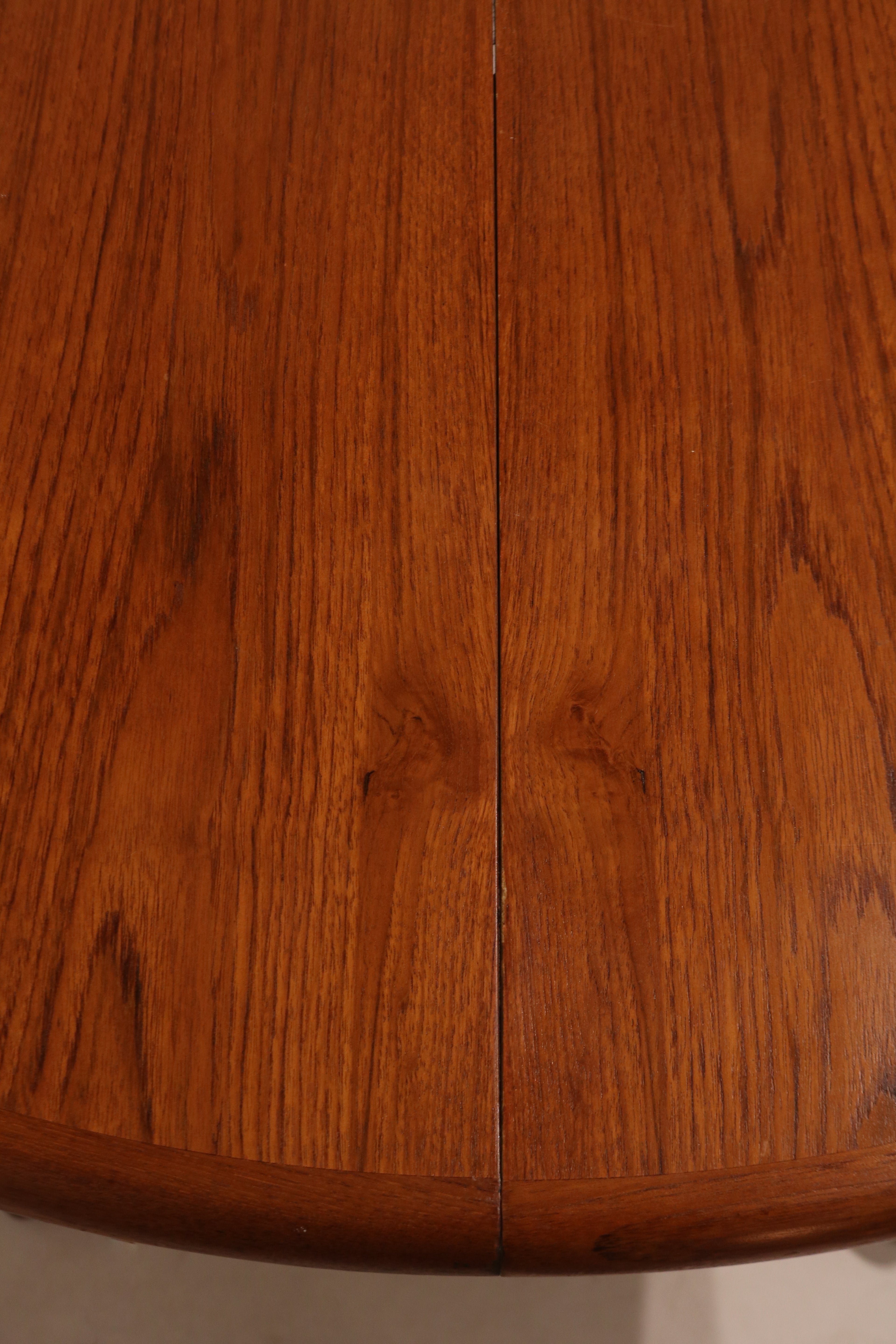 Close-up of extended table with leaf inserted, transforming into large oval shape