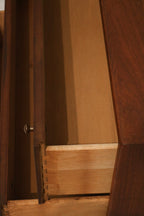 Angled view of top surface showing polished walnut wood and clean linear design
