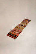 Vintage Anatolian runner kilim rug on wooden floor
