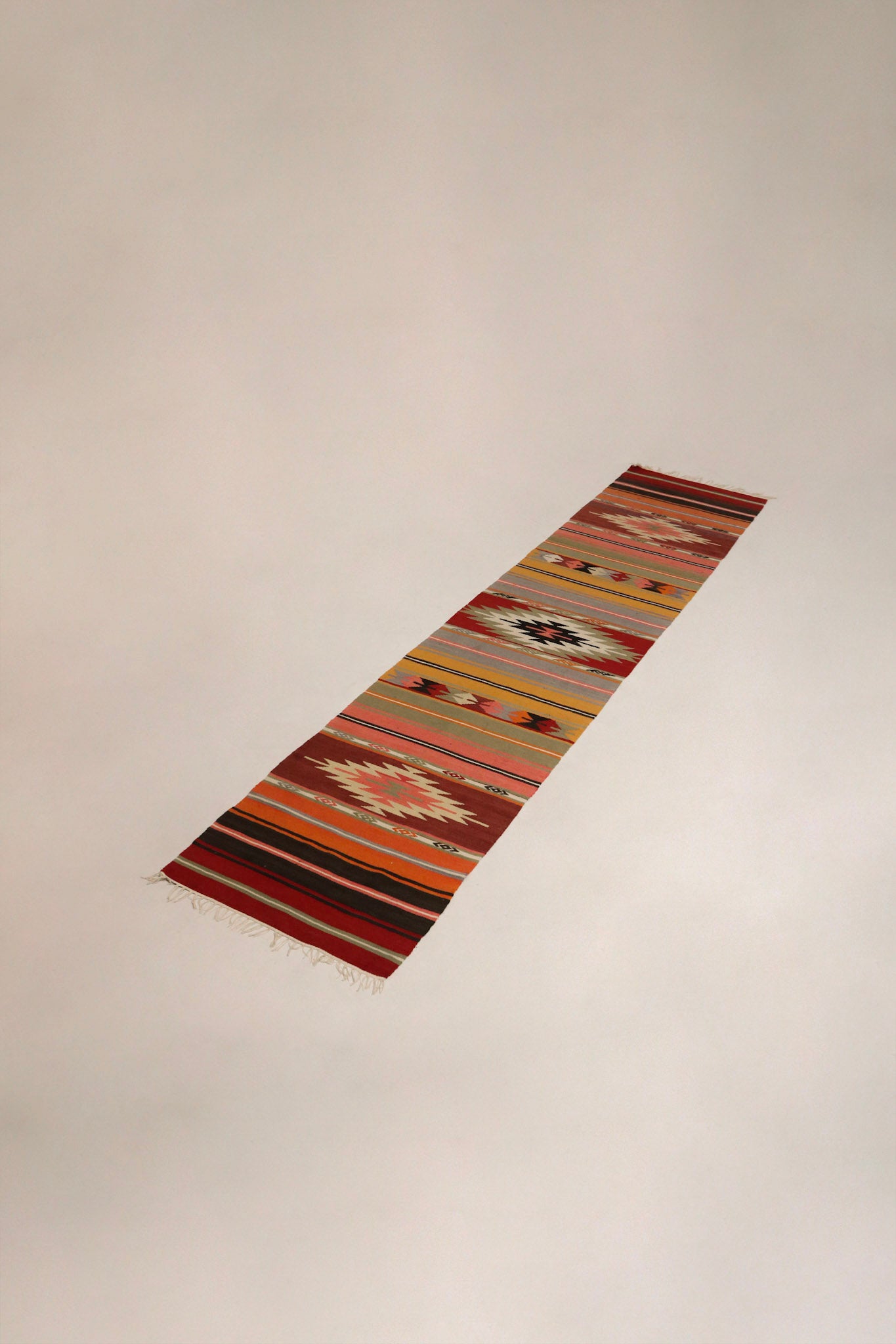 Vintage Anatolian runner kilim rug on wooden floor